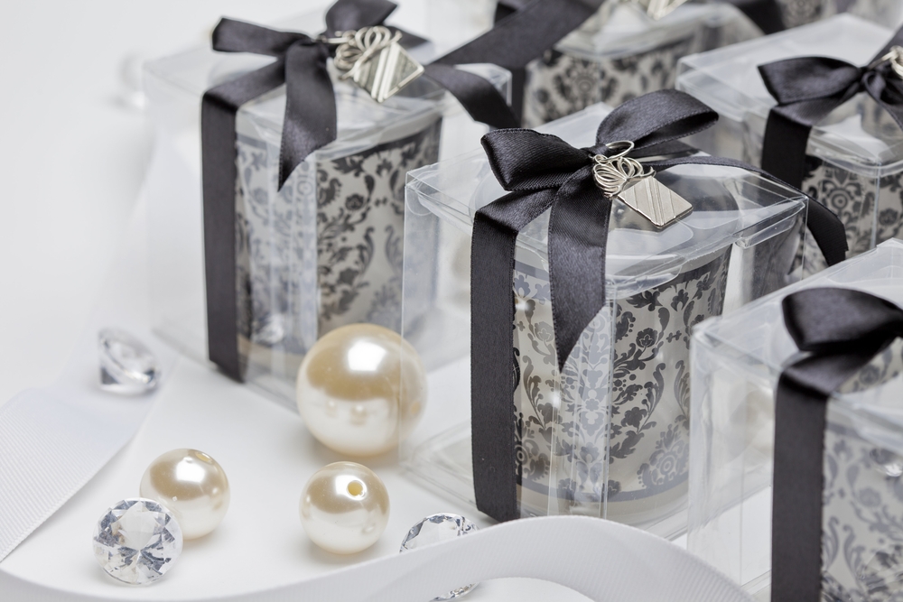 black and white candle wedding favors with pearls and diamonds on table