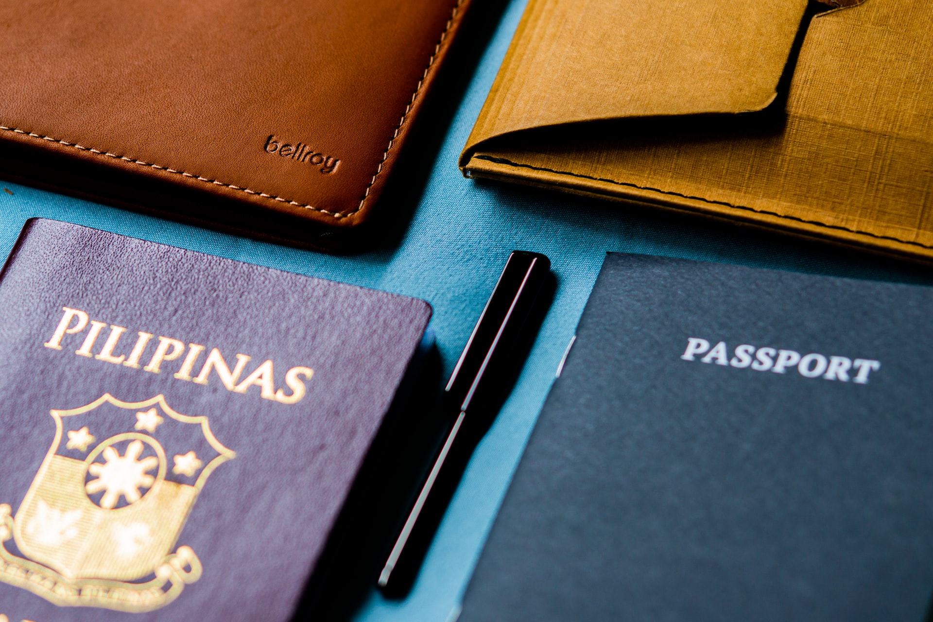 close up of flat lay passport, wallet, pen, and notebook on table