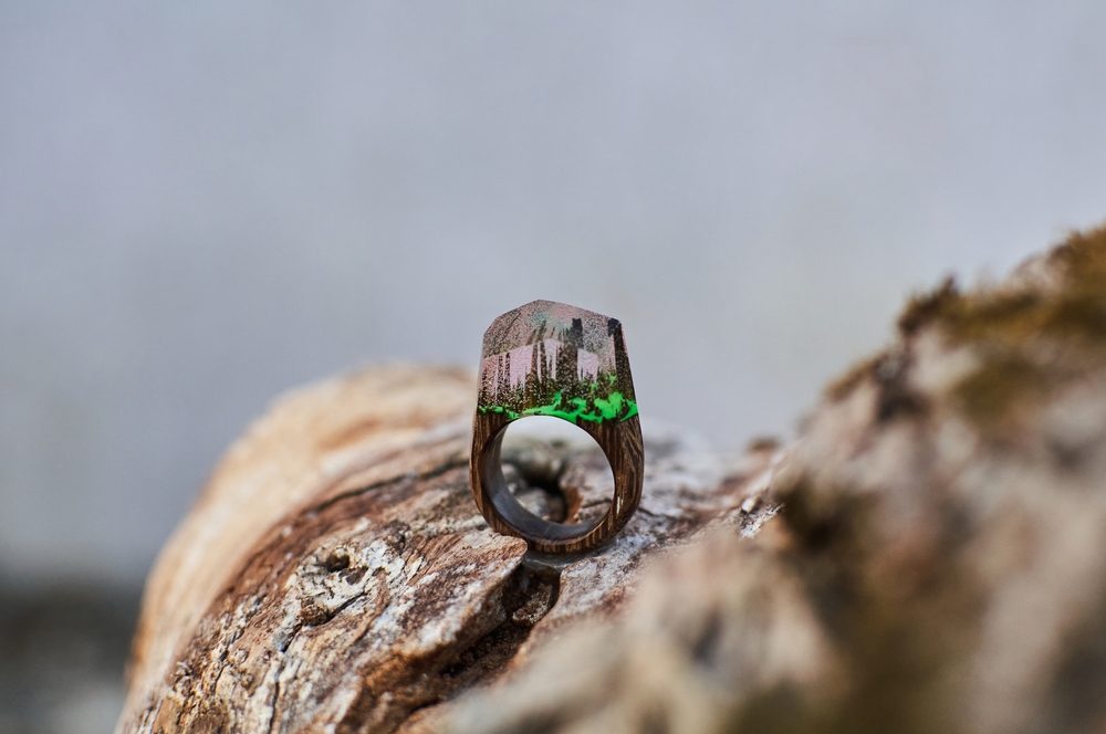 nature scenery ring made of epoxy resin lying on a texture cut of a tree