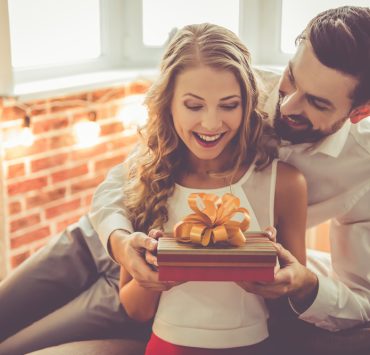 couple holding an anniversary gift box indoor