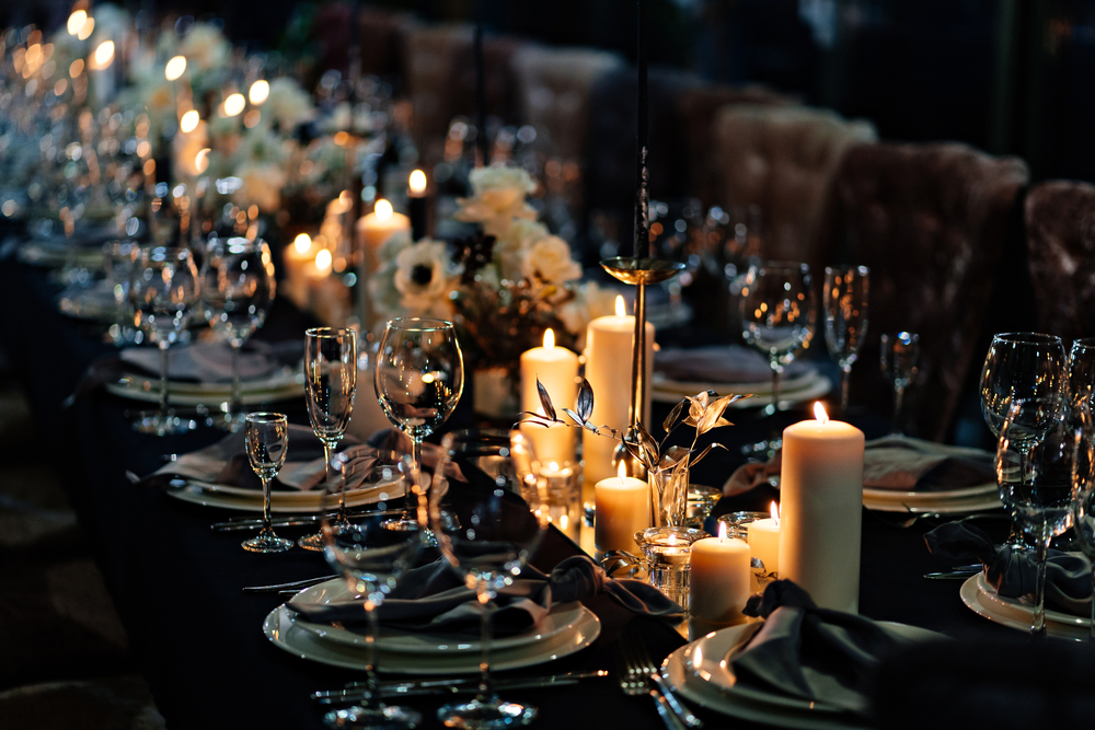 wedding table setting with lit candles in the dark