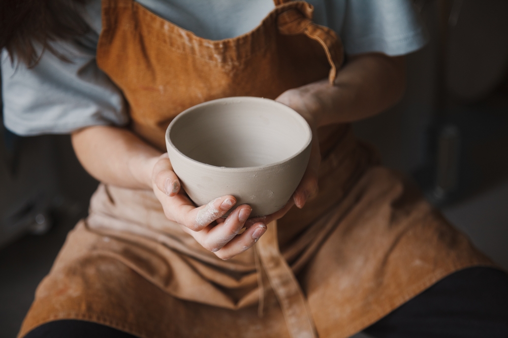 woman holding a finished pottered bowl