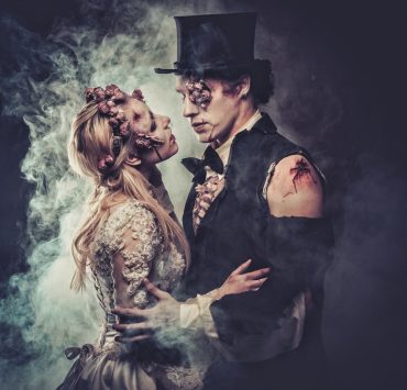 zombie bride and groom touching and facing each other on gothic themed wedding