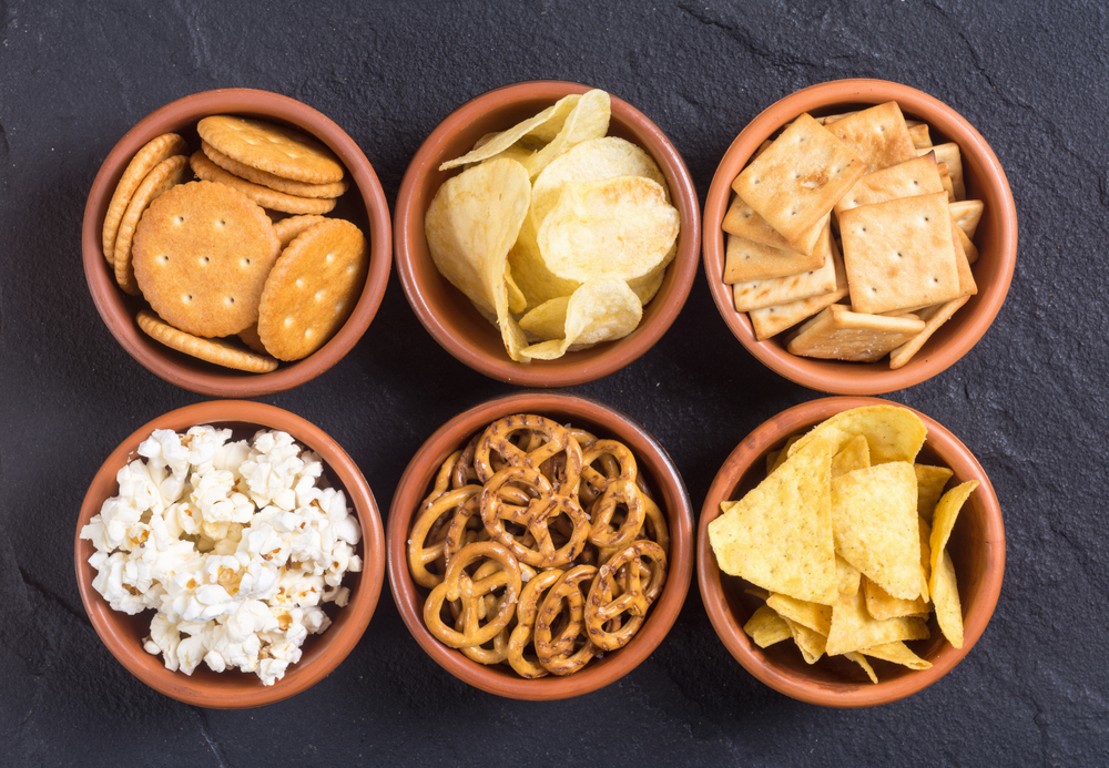 Mix of bar snacks pretzels crackers chips nuts popcorn and nachos