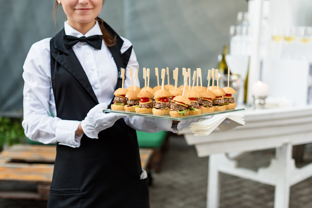  Waitress carrying a tray of classic sliders burgers