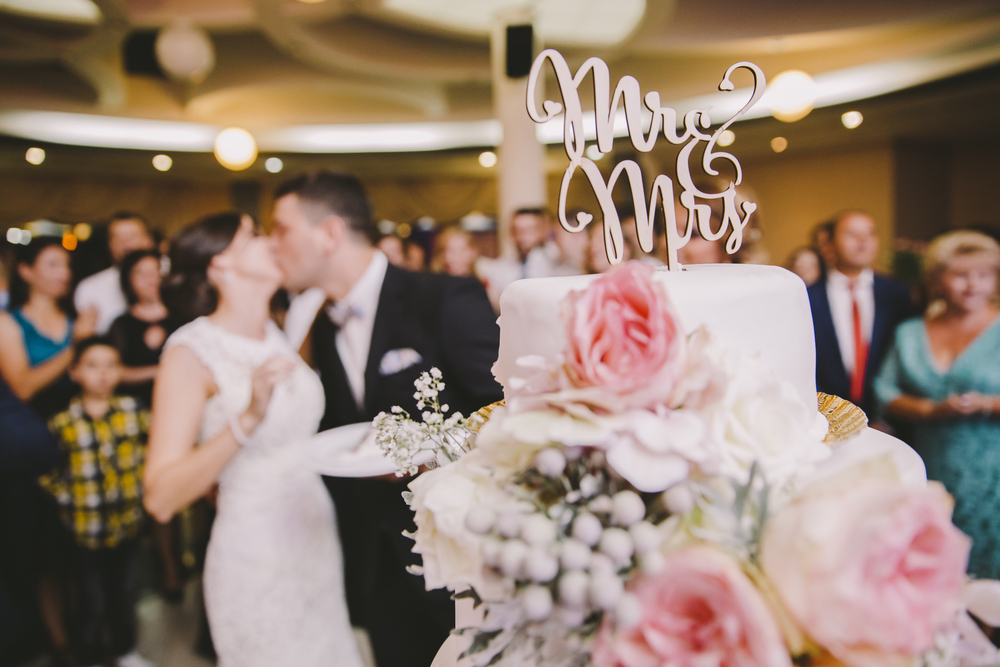 camera focused on wedding cake with ms and mrs sign