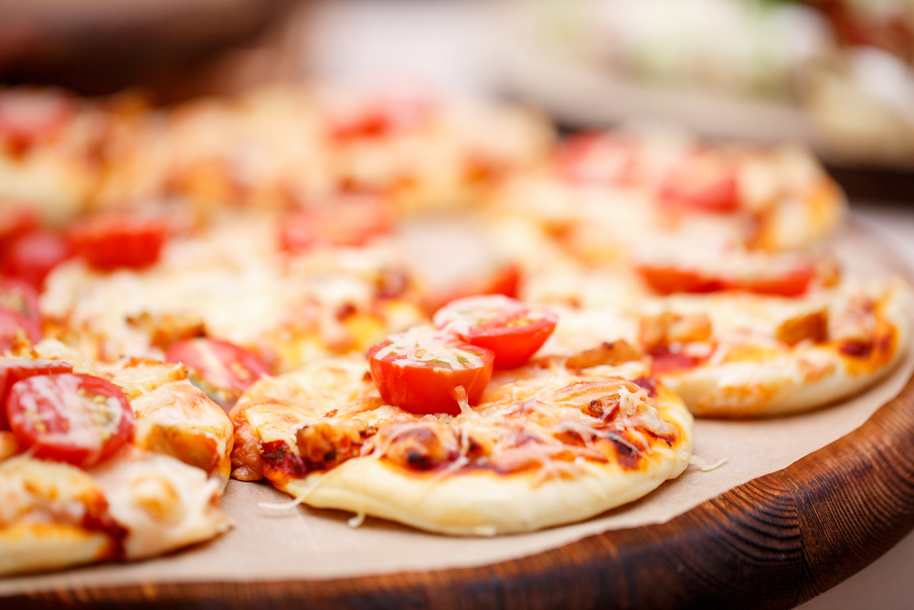 mini pizzas on wood plate on wedding catering