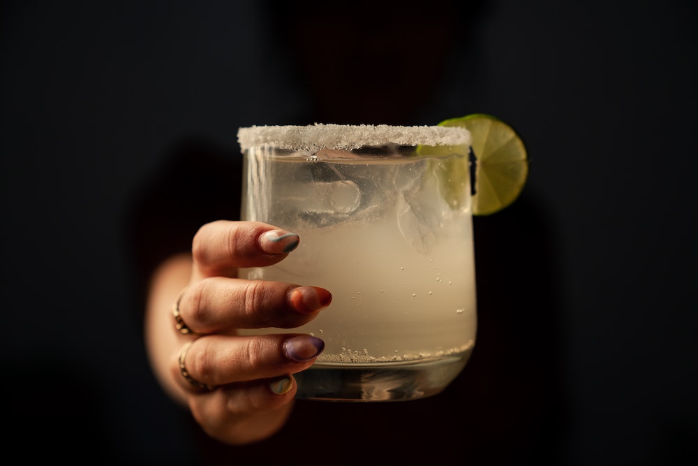 A female hand Holding a Glass Cup of Margarita
