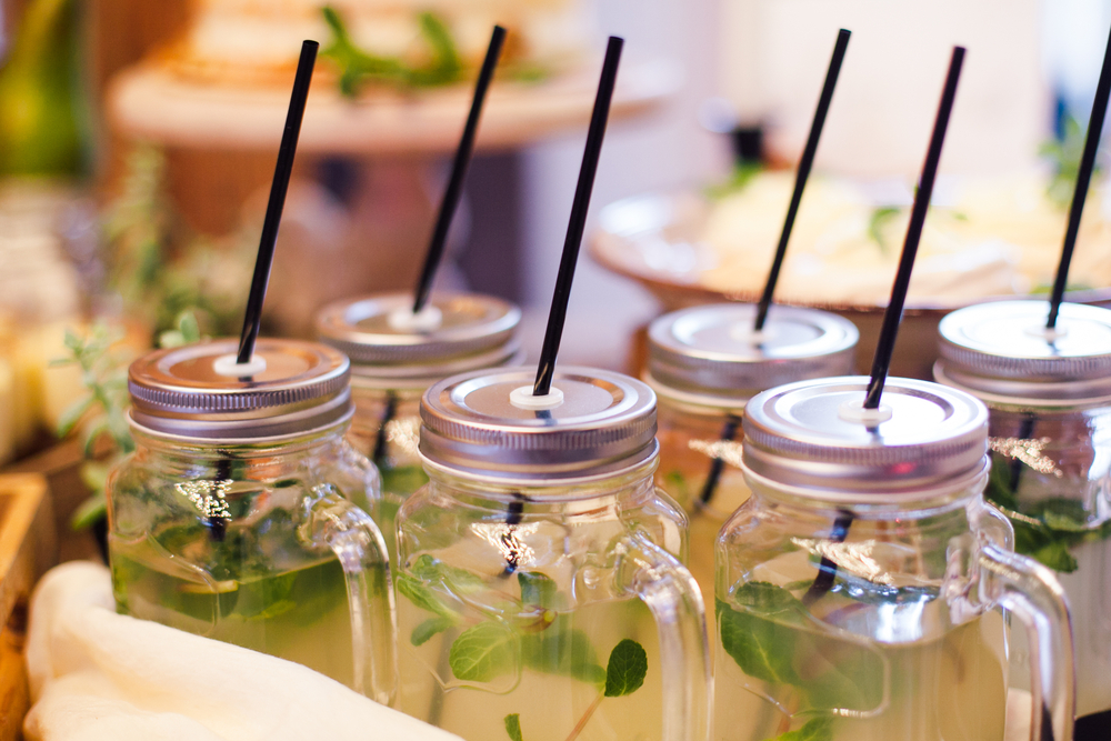 Lemonade with mint in glass cup with straws in area of wedding party