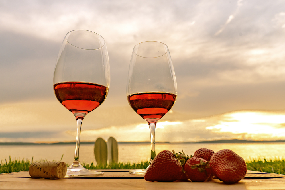 Sunset Rosé with strawberries low angle view with dramatic sunset sky