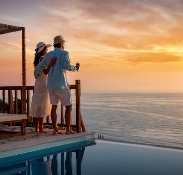 A romantic couple watching sunset over the sea on their second honeymoon