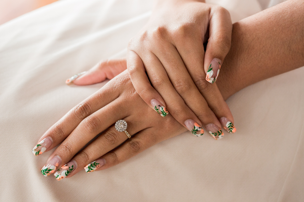 Close up of large round halo wedding engagement diamond ring on female ring finger