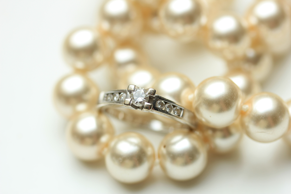 Diamond engagement ring in a channel setting and a pearl necklace