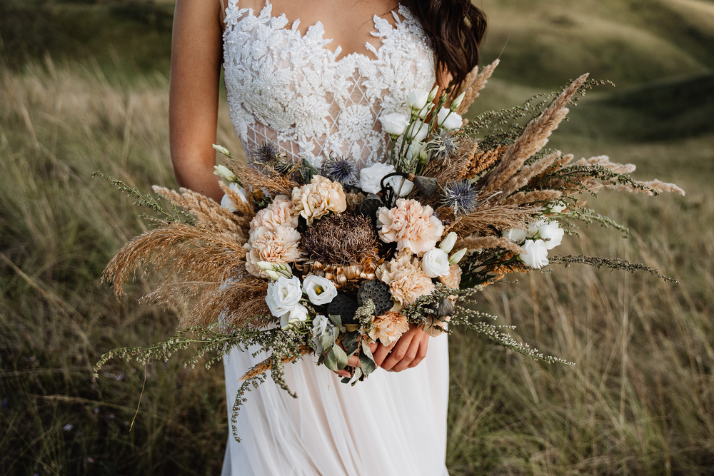 bride holding an intricate boho style of bouquet