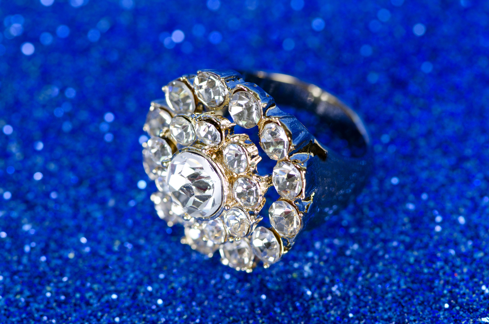 diamond cluster setting ring on blue glittery background
