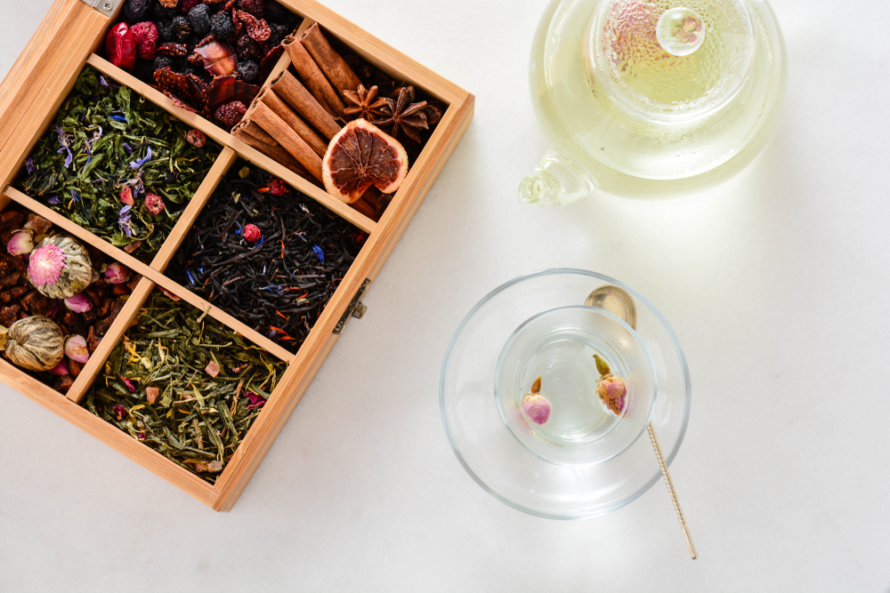 six aromatic dry teas in wooden box with two cups of tea