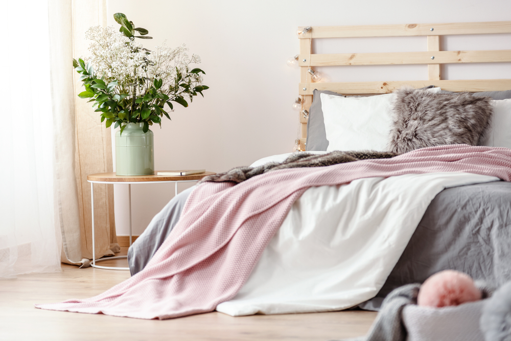 King-size bed with grey sheets and pink blanket