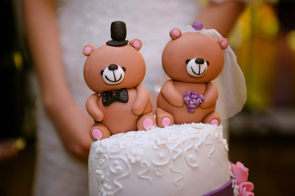 wedding cake with bride and groom teddy bears at the top