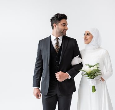 a muslim bride with bouquet smiling at the groom on interfaith wedding