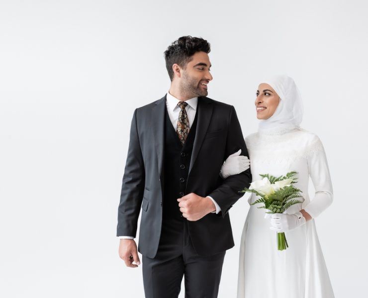 a muslim bride with bouquet smiling at the groom on interfaith wedding