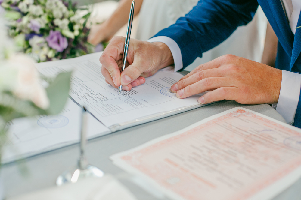 bride and groom signing a marriage paper