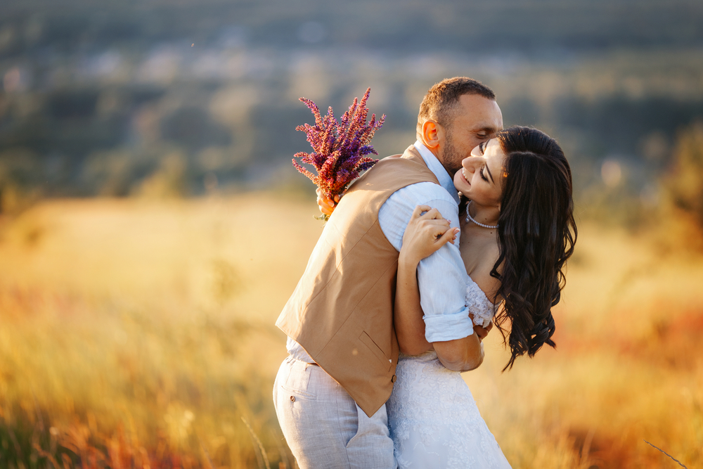 couple kissing and hugging during sunset