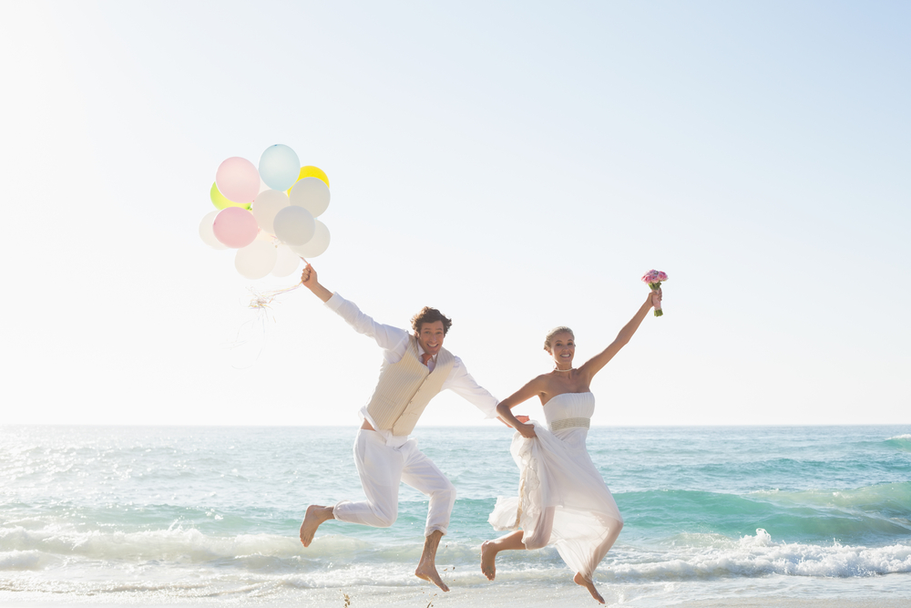 jumpshot of a couple holding balloons and flower
