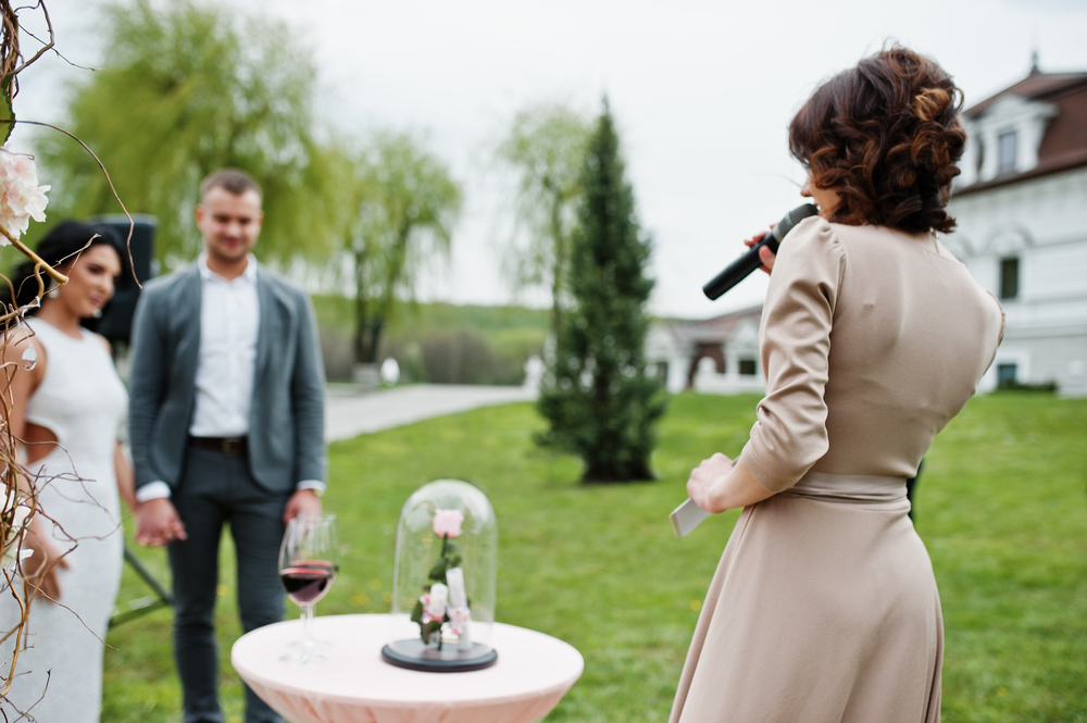 maid of honor giving a speech in front of a couple outdoor