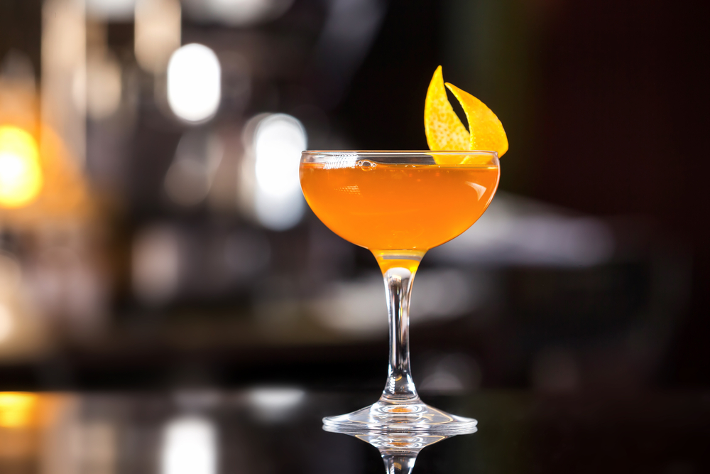 Glass of sidecar orange mocktail decorated with lemon 