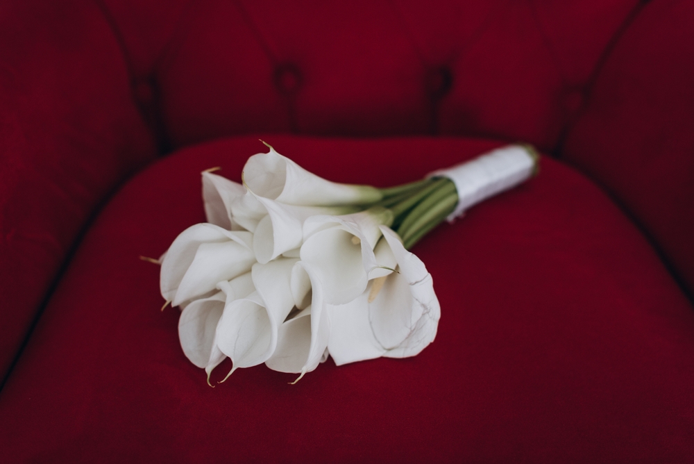 a bouquet of white lilies on red couch