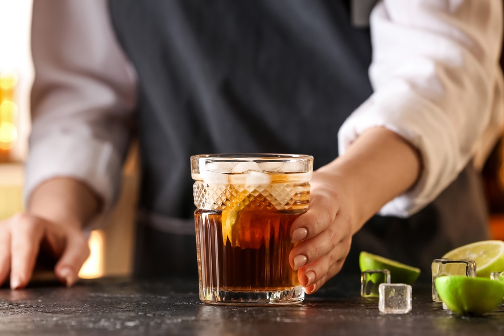 bartender with glass of tasty Cuba Libre mocktail