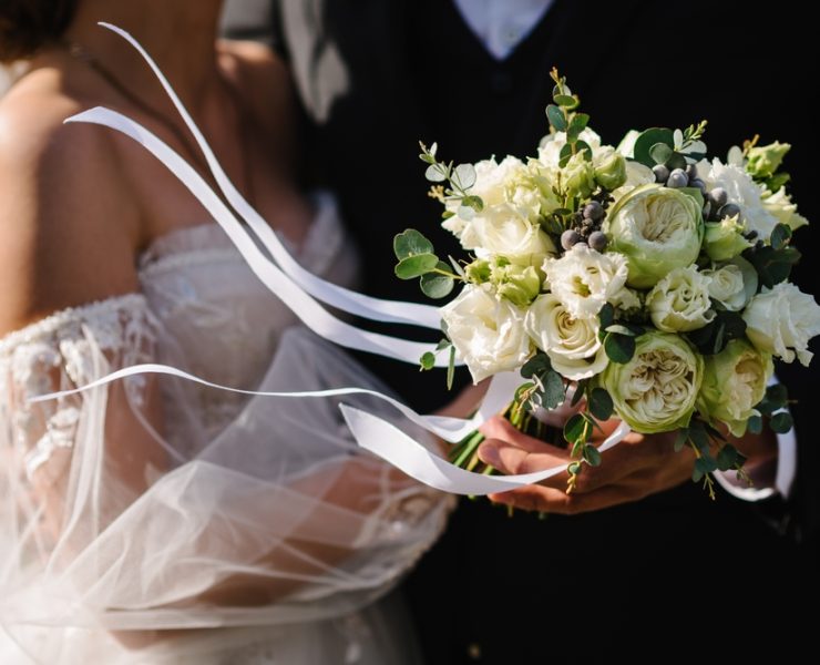 bride and groom holding a wedding bouquet
