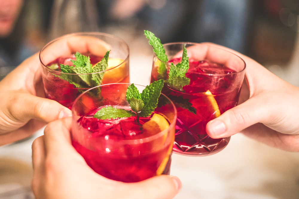 hands of people toasting non alcoholic sangria