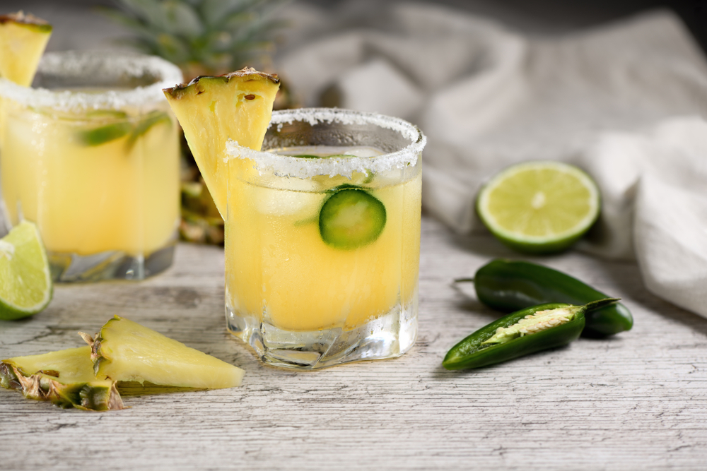 two glasses of Chili Lime Pineapple Soda with chili and lime slices