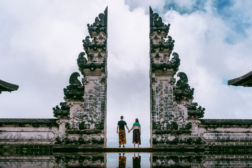 Young couple standing and holding hands at Lempuyang Luhur temple in Bali, Indonesia