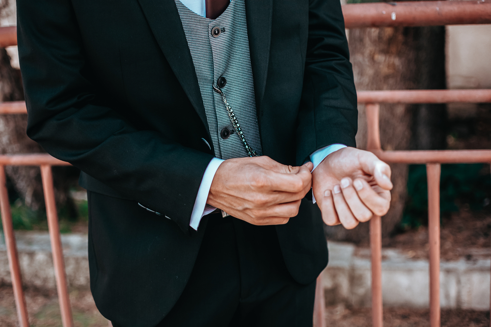 man cuffing his vintage suit