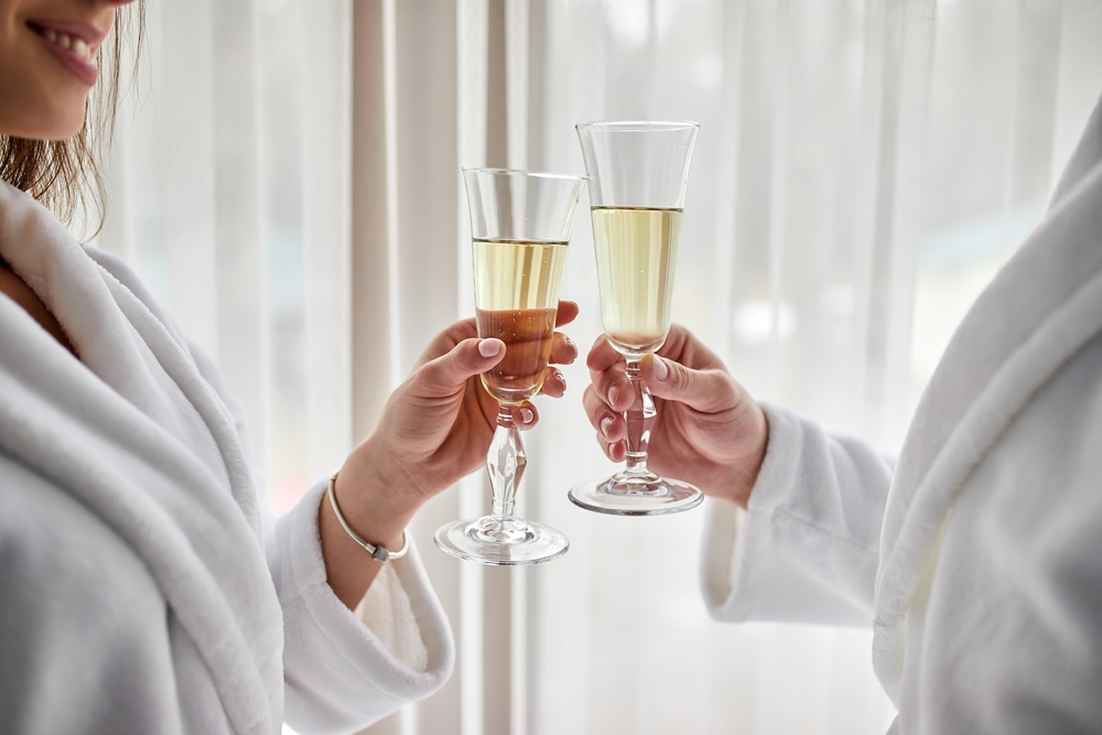newly wed clinking white champagne glasses