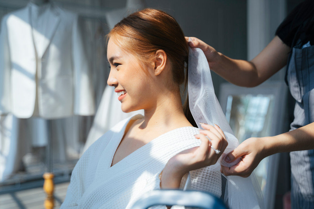 hairstylist doing a ponytail hairstyle on bride