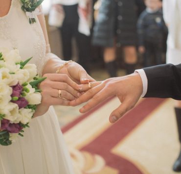 bride putting a ring on the groom's finger