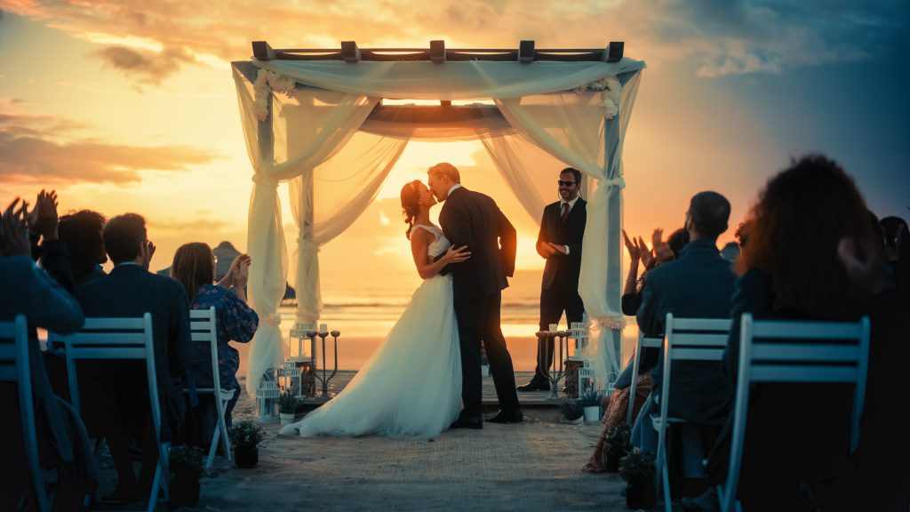 bride and groom kissing in the sunset