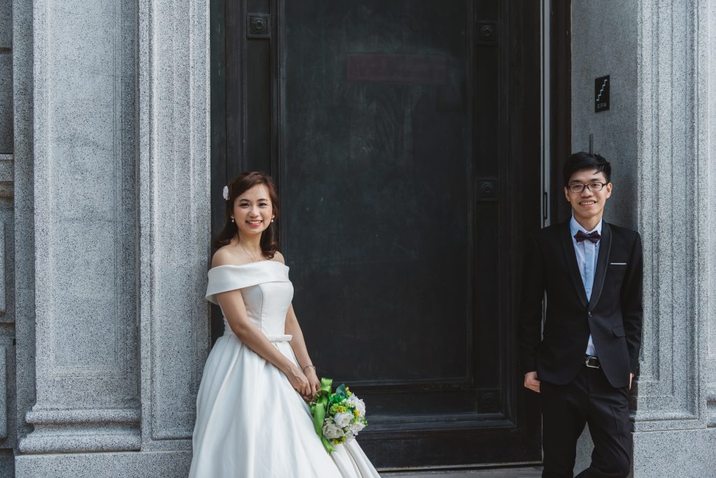 the bride and groom posing outside the church