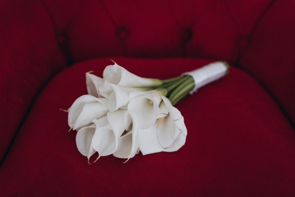 bouquet of white flowers placed in a red velvet chair