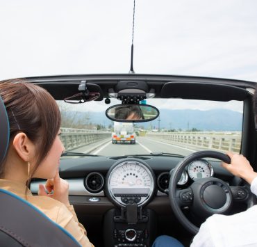 two couples driving an open car