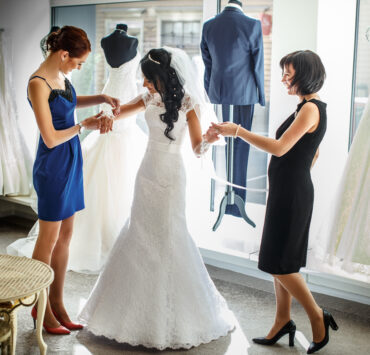 a bride to be trying a wedding gown
