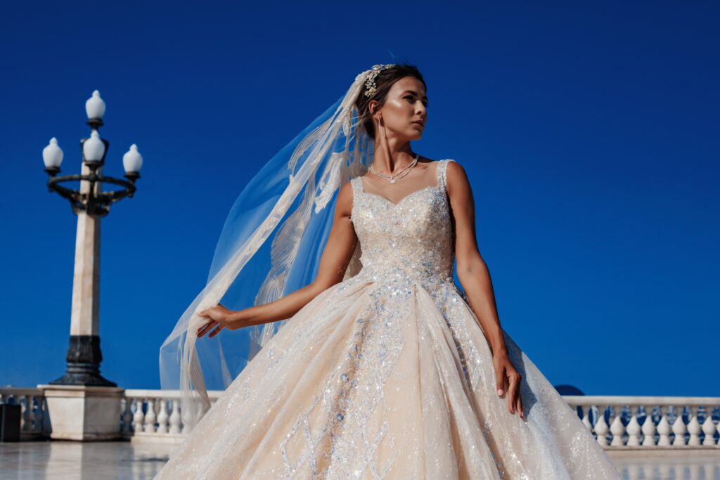 a bride in her wedding gown against a clear sky