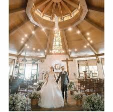 A unique circular chapel with a red roof and glass walls, offering a panoramic view of the mountains.