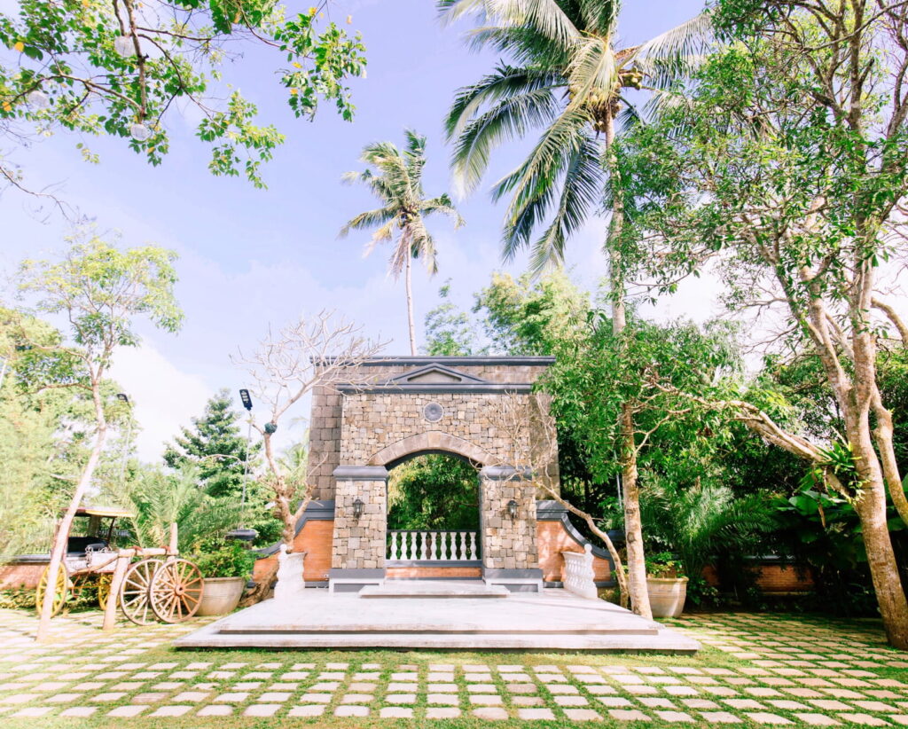 A tiered outdoor amphitheater-style garden venue with stone steps and vibrant green hedges.