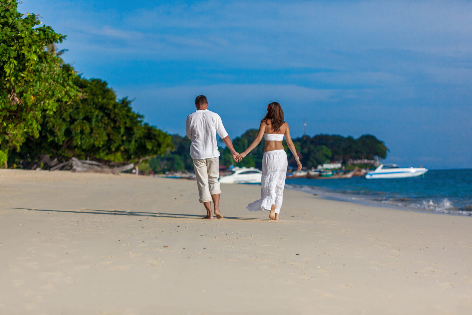 A couple walking hand-in-hand on the beach