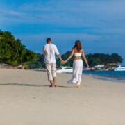 A couple walking hand-in-hand on the beach