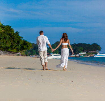 A couple walking hand-in-hand on the beach
